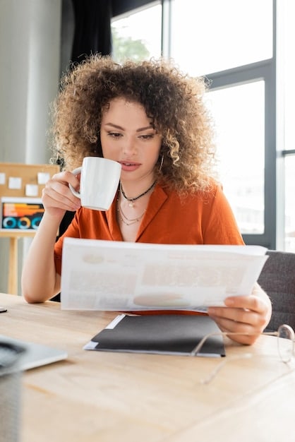 An image showing a small business owner smiling while reviewing loan documents next to a computer displaying positive financial forecasts.