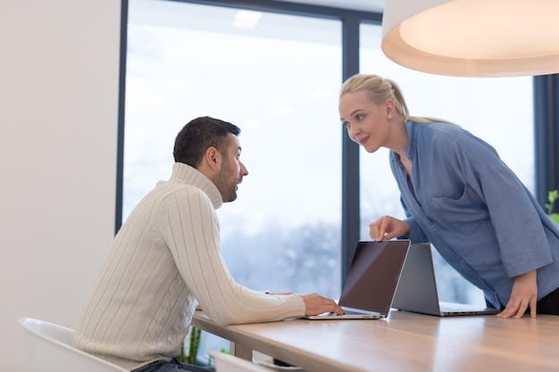 A manager having a supportive conversation with an employee in a bright and modern office space. The manager is gesturing kindly while the employee is listening attentively, conveying a sense of trust and open communication.  In the background, other employees are working collaboratively, contributing to a positive and supportive atmosphere.