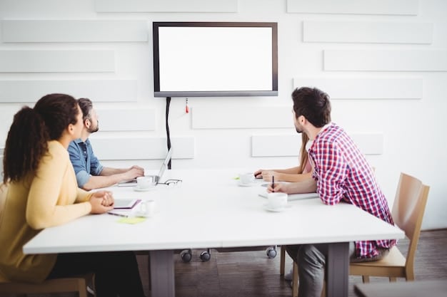 A team meeting in a conference room, where employees are brainstorming ideas on a whiteboard. They are discussing how education and new skills can benefit the company's goals. The atmosphere is collaborative and innovative.