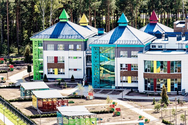A rendering of a neighborhood with a mix of modular homes and 3D-printed houses, integrated with green spaces and community amenities like co-working spaces and shared gardens. Focus on the sustainable aspects of the designs.