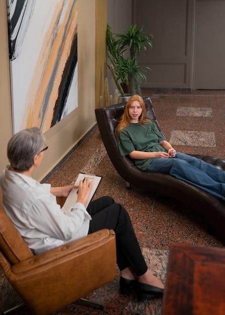 A person talking to a therapist in a bright, comfortable office setting. The therapist is listening attentively and taking notes. The atmosphere conveys trust and support.
