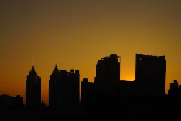 A cityscape viewed at sunset, where some buildings are lit up while others are shadowed, representing the mix of challenges and opportunities in urban life and the need for resilience to navigate them.