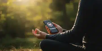 Person meditating with phone showing no notifications, symbolizing digital detox